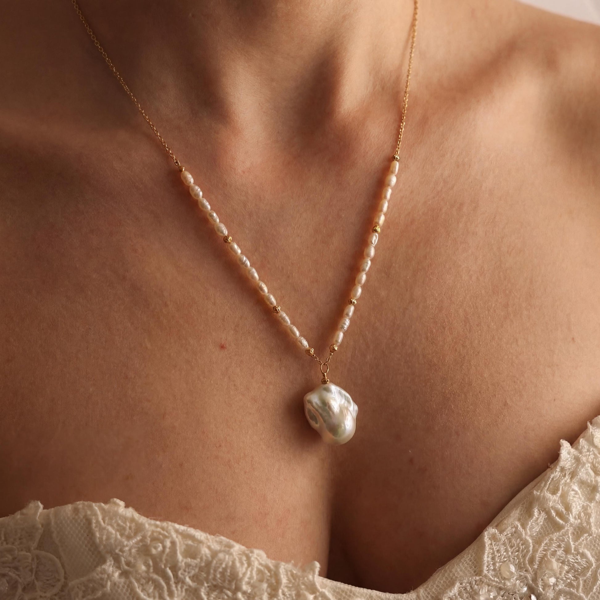 Pearl necklace worn by a person with a blurred background