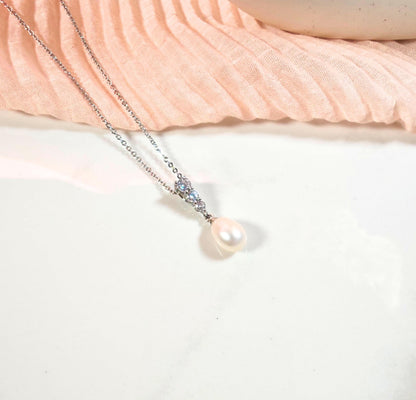 Pearl necklace with silver chain on a soft fabric background