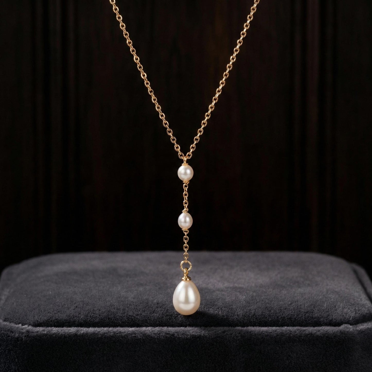 Pearl necklace with gold chain on a dark background