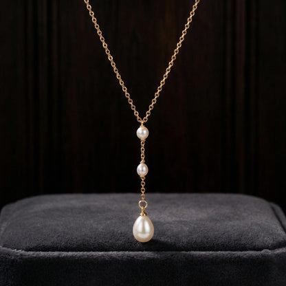 Pearl necklace with gold chain on a dark background