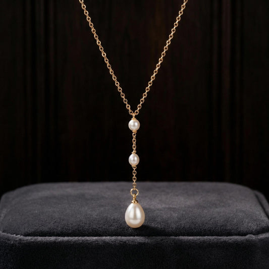 Pearl necklace with gold chain on a dark background