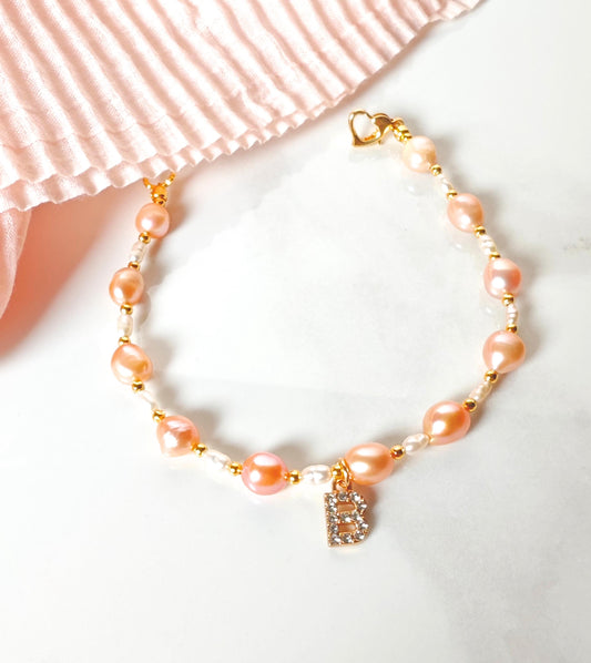 Pearl bracelet with a heart charm on a white background
