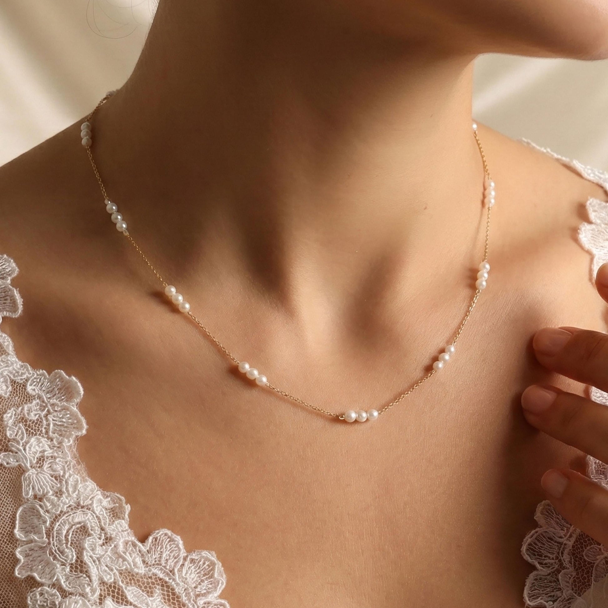 Pearl necklace worn by a person with a lace garment