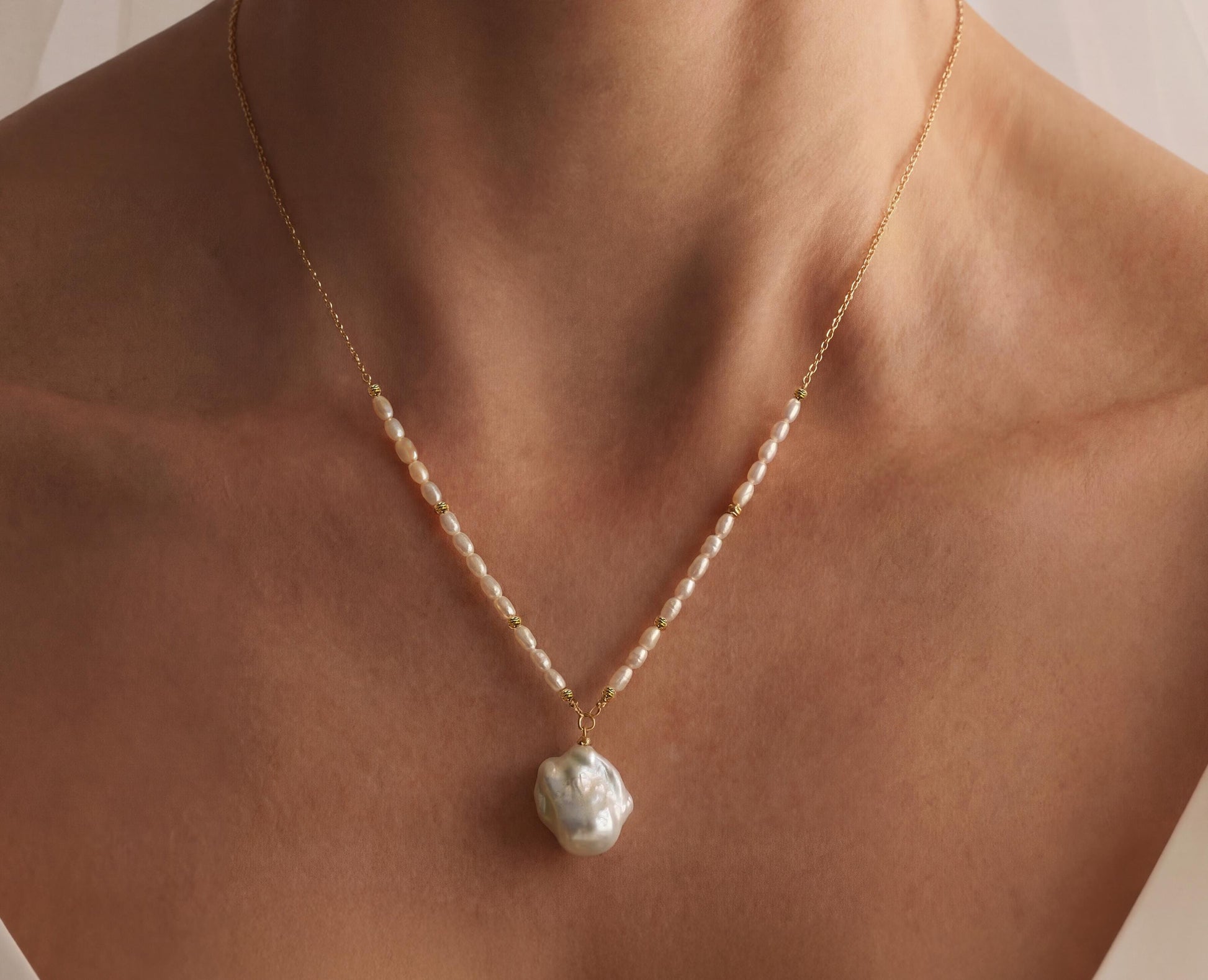 Pearl necklace on a person's neck with a neutral background