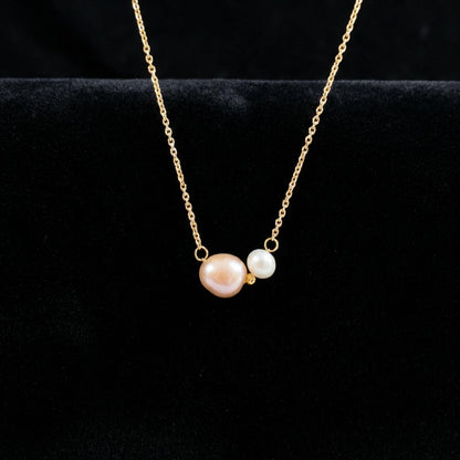 Gold necklace with two pearls on a black background
